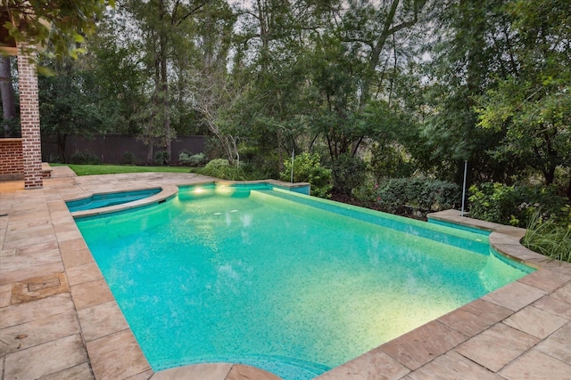 view of swimming pool featuring a patio area and an in ground hot tub