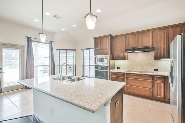 kitchen featuring appliances with stainless steel finishes, sink, a center island with sink, and decorative light fixtures