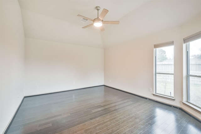 empty room with ceiling fan, dark hardwood / wood-style floors, and vaulted ceiling