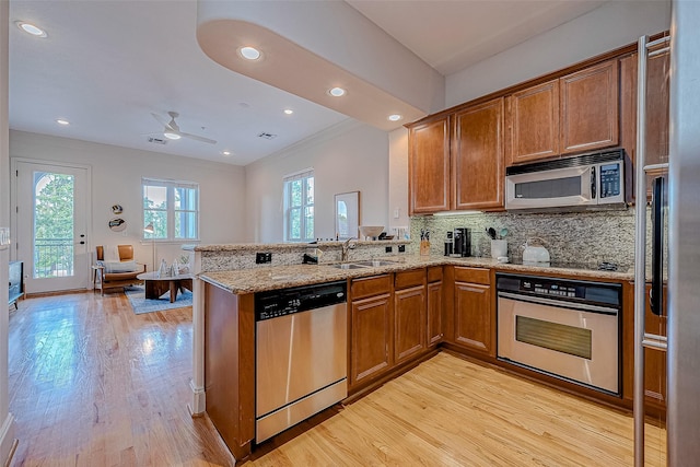 kitchen featuring sink, ceiling fan, light wood-type flooring, kitchen peninsula, and stainless steel appliances