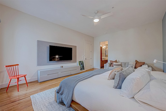 bedroom with ensuite bath, ceiling fan, and light wood-type flooring