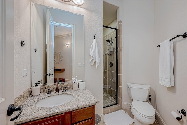 bathroom featuring a shower with door, vanity, and toilet