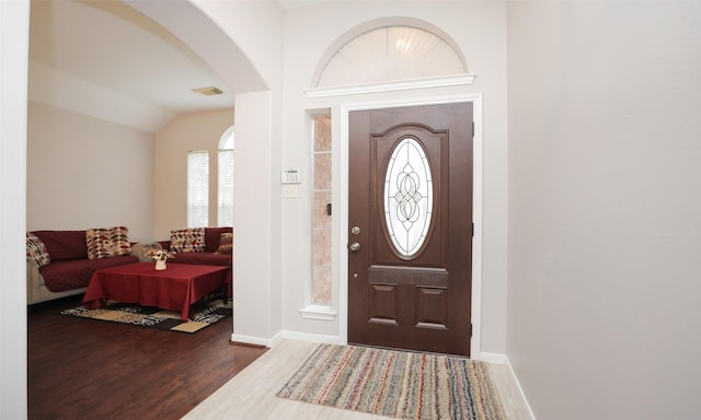 entryway with dark wood-type flooring and lofted ceiling