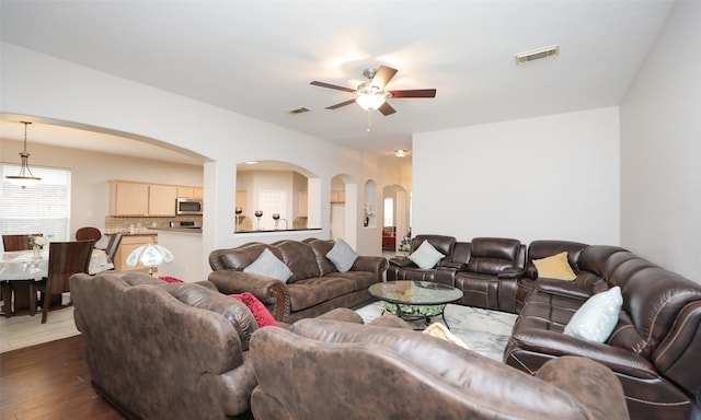 living room featuring ceiling fan and dark hardwood / wood-style floors