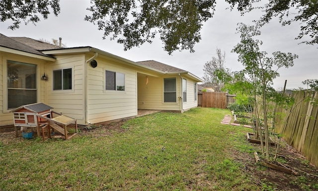 rear view of property featuring a lawn