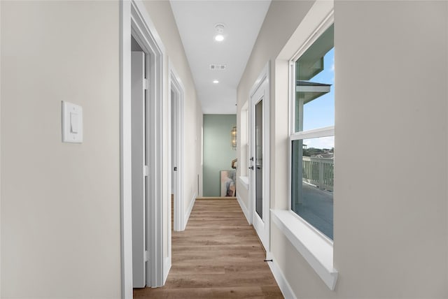 corridor with light hardwood / wood-style floors