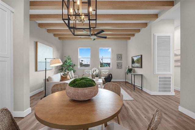 dining area with beamed ceiling, ceiling fan with notable chandelier, and light wood-type flooring