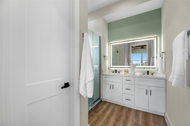 bathroom with vanity, wood-type flooring, and walk in shower