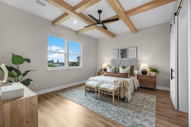 bedroom with a barn door, ceiling fan, coffered ceiling, and hardwood / wood-style flooring