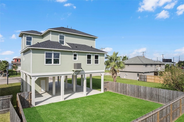 rear view of property featuring a yard, a patio, and central air condition unit