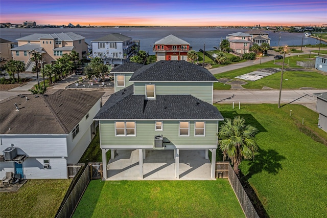 exterior space featuring cooling unit, a water view, and a garage