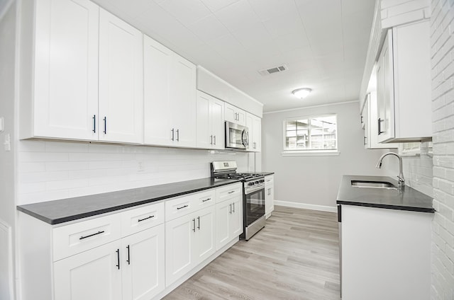 kitchen featuring white cabinets, sink, stainless steel appliances, and tasteful backsplash