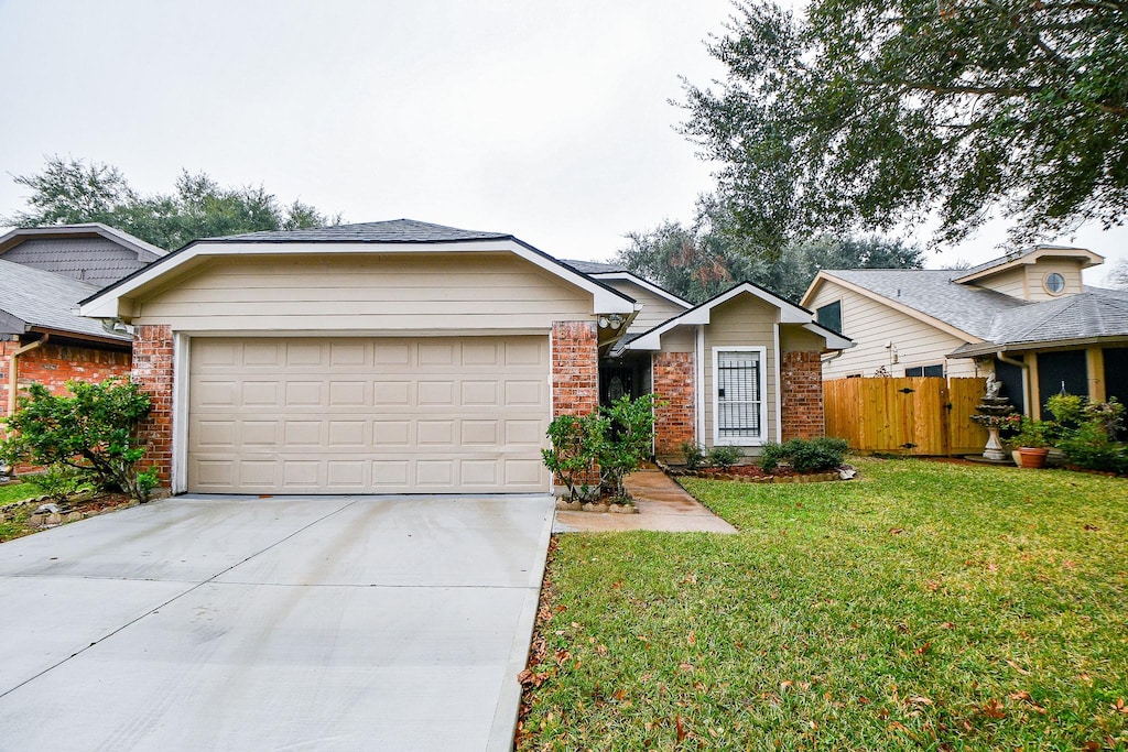 ranch-style house featuring a garage and a front lawn