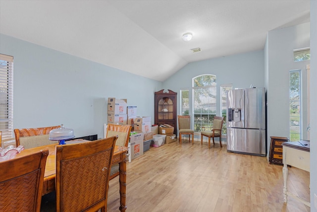 dining room with light hardwood / wood-style flooring and lofted ceiling