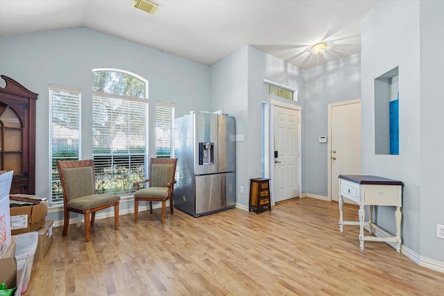 living area with light wood-type flooring and lofted ceiling