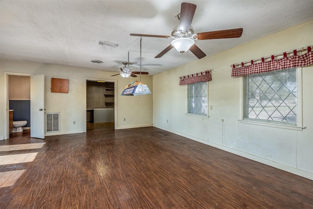 spare room featuring dark hardwood / wood-style flooring, a textured ceiling, and ceiling fan