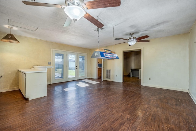 unfurnished living room with french doors, a textured ceiling, and dark wood-type flooring