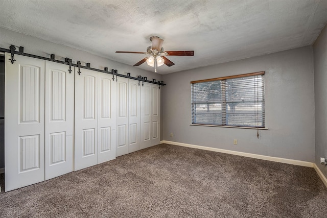 unfurnished bedroom featuring a textured ceiling, carpet floors, and ceiling fan