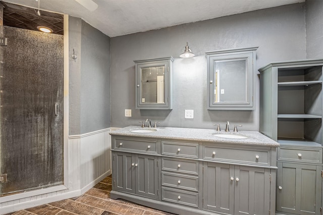 bathroom with vanity and a shower with door