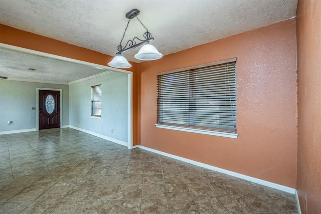 unfurnished room featuring ornamental molding and a textured ceiling