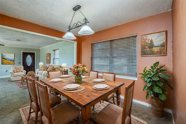 tiled dining room with crown molding and a textured ceiling