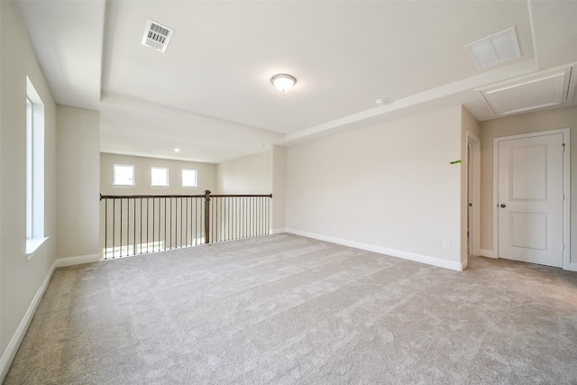 spare room with carpet floors, baseboards, and attic access