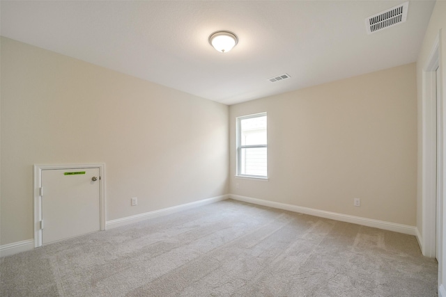 unfurnished room with light carpet and baseboards