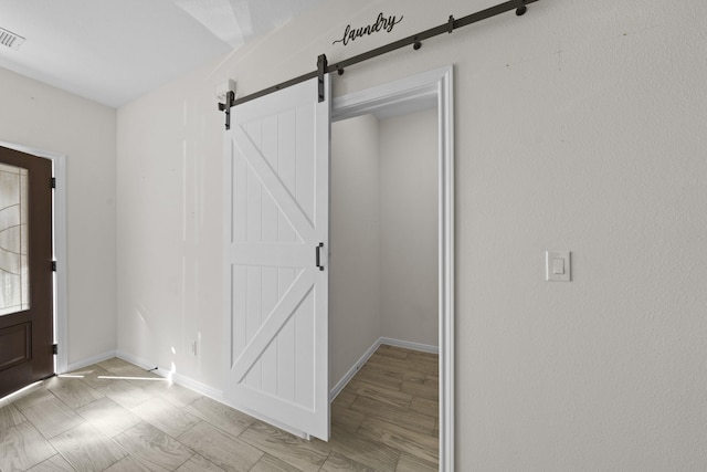 entryway with a barn door and light hardwood / wood-style flooring