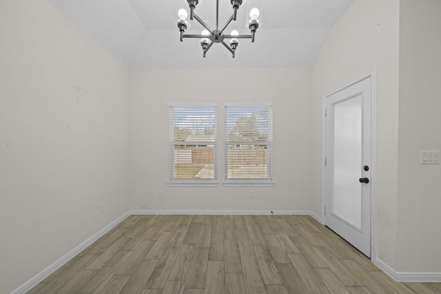 unfurnished dining area with lofted ceiling, a notable chandelier, and light hardwood / wood-style floors