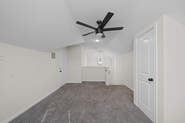 additional living space with ceiling fan, lofted ceiling, carpet flooring, and a textured ceiling