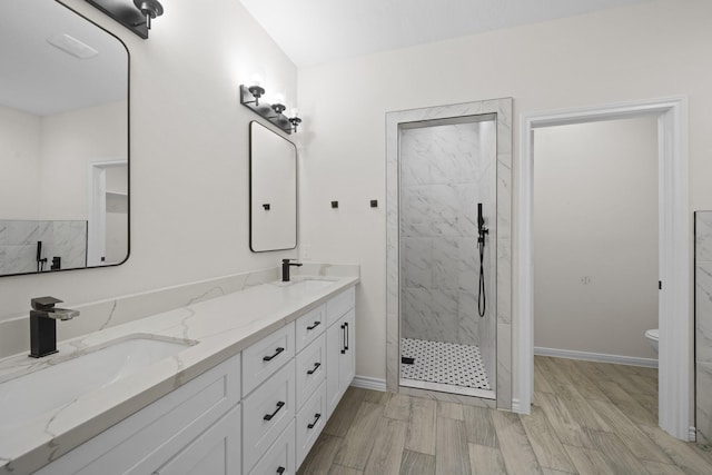 bathroom with vanity, hardwood / wood-style floors, toilet, and tiled shower