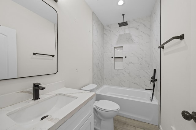 full bathroom with tiled shower / bath, vanity, toilet, and wood-type flooring