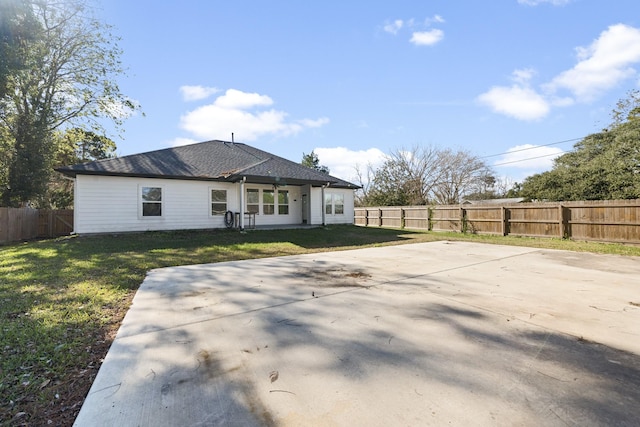 rear view of property featuring a yard