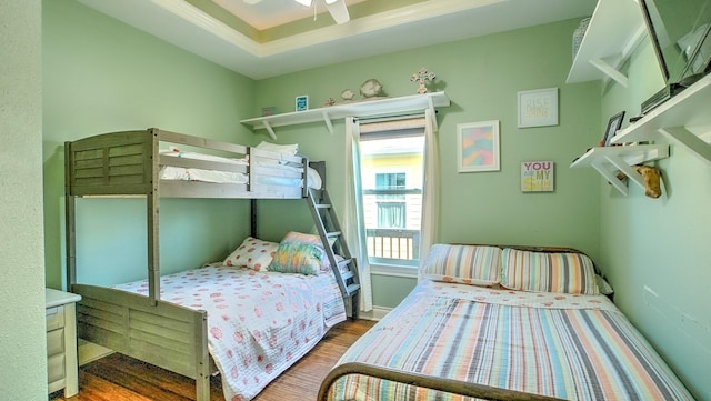 bedroom with wood-type flooring, ceiling fan, and crown molding