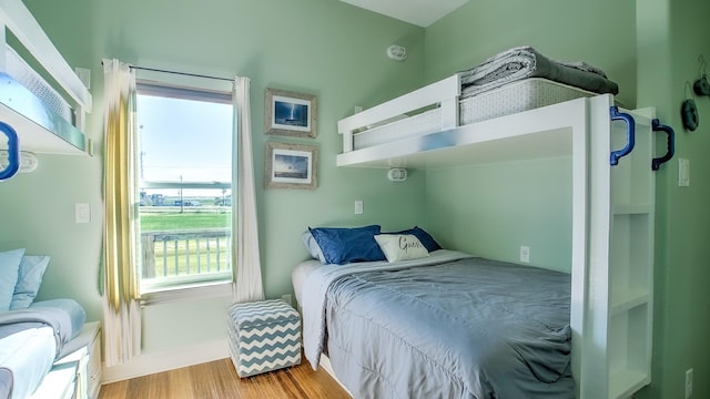 bedroom with light hardwood / wood-style floors and multiple windows