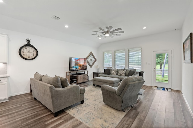 living room with hardwood / wood-style flooring, ceiling fan, and vaulted ceiling