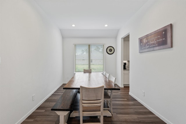 dining space with vaulted ceiling and dark hardwood / wood-style flooring