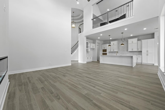 unfurnished living room with a high ceiling and an inviting chandelier