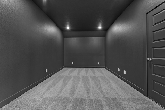 carpeted spare room featuring vaulted ceiling