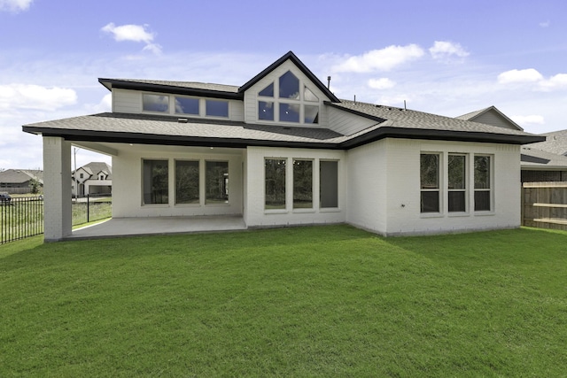 rear view of house with a lawn and a patio