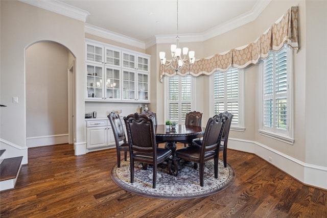 dining room with dark wood-type flooring, crown molding, and a chandelier