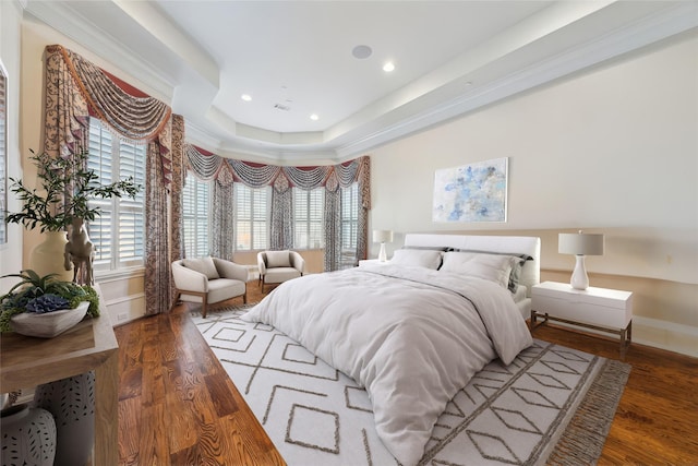 bedroom with a raised ceiling, dark hardwood / wood-style flooring, and ornamental molding