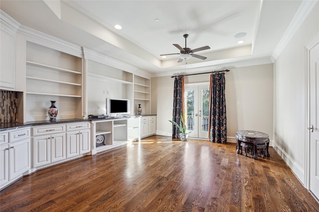 unfurnished living room featuring ceiling fan, a tray ceiling, and hardwood / wood-style floors