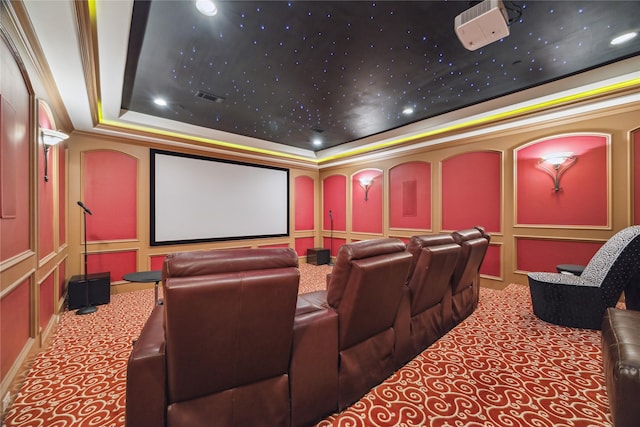 carpeted cinema featuring crown molding and a raised ceiling