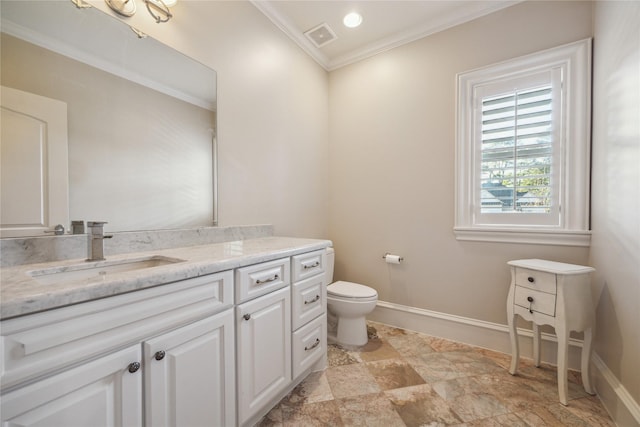 bathroom with toilet, vanity, and ornamental molding