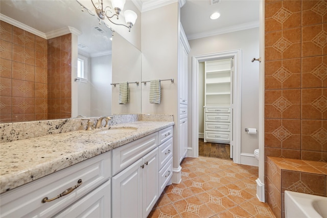 bathroom with toilet, a tub to relax in, tile patterned flooring, crown molding, and vanity