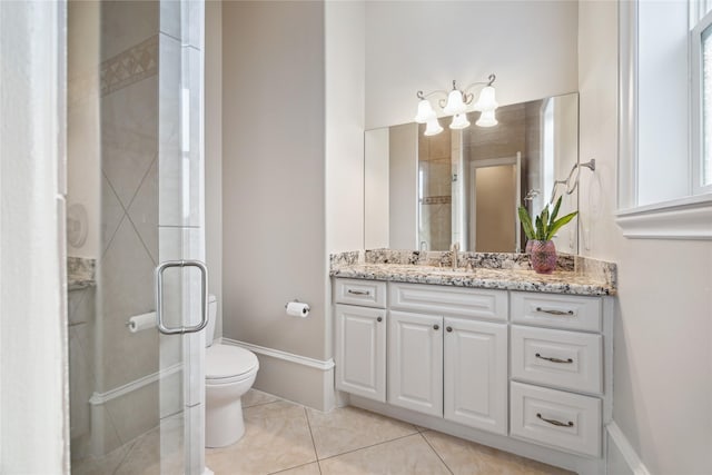 bathroom featuring toilet, tile patterned flooring, a shower with shower door, and vanity