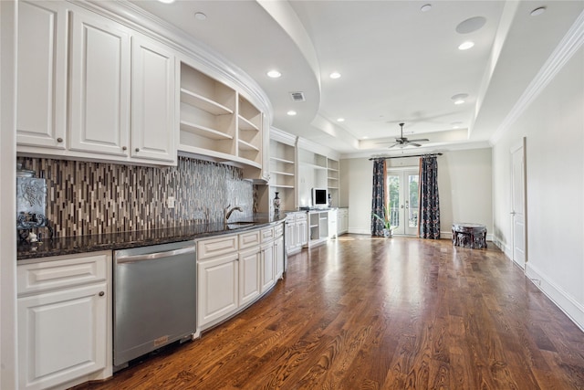 kitchen featuring stainless steel dishwasher, white cabinetry, dark hardwood / wood-style flooring, ceiling fan, and a tray ceiling