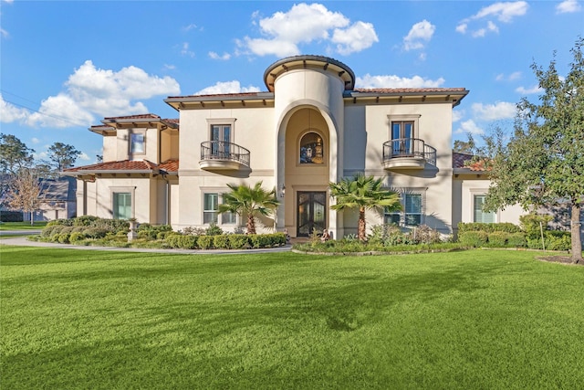 mediterranean / spanish house with a front lawn and a balcony