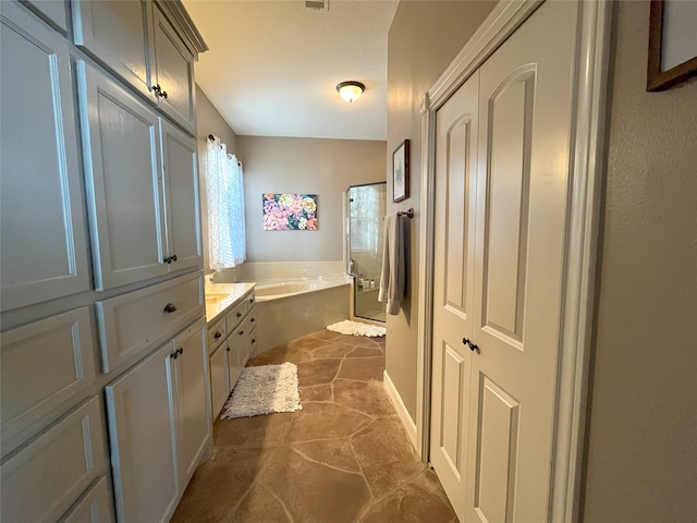 bathroom with vanity and shower with separate bathtub